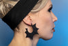 Spooky black bat wing earrings displayed on a gothic model with blonde hair. 3d printed jewelry made in Salem, Massachusetts  by jewelry designer Hypnovamp.