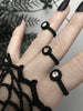 Close up of 3 simple matte black rings with white swarovski crystal stones, displayed on a gothic model's hand with long black nails. 3d printed jewelry by Hypnovamp.