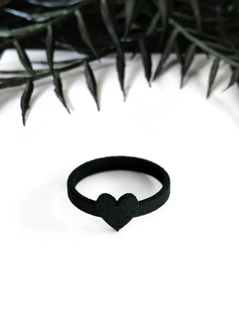 Cute 3d printed black ring with heart design, displayed on white background with a black foliage border.