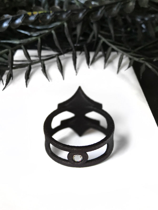 Backside of 3d printed black ring with swarovski crystals and a dark space age sci-fi style. Displayed on a white background with black foliage.