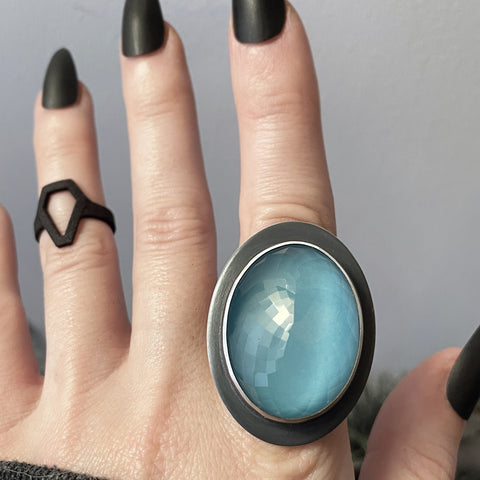 Space age sterling silver glow ring featuring a faceted rose quartz crystal ball, displayed on a goth model hand with long black nails and a 3d printed black coffin ring. Fancy handmade glow jewelry by Salem, MA jewelry designer Hypnovamp.