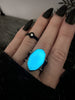 Handmade sterling silver blue glow ring modeled on a gothic hand with long black nails. High end glow in the dark jewelry by witchy jewelry artist Hypnovamp in Salem Massachusetts.