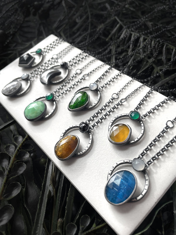 Handmade silver gemstone necklaces featuring black onyx, midnight quartzite, clear quartz moon, chrysoprase, chrome diopside, petra tourmaline, montana agate, and blue apatite. Witchy jewelry handcrafted in Salem Massachusetts by jewelry designer Hypnovamp.